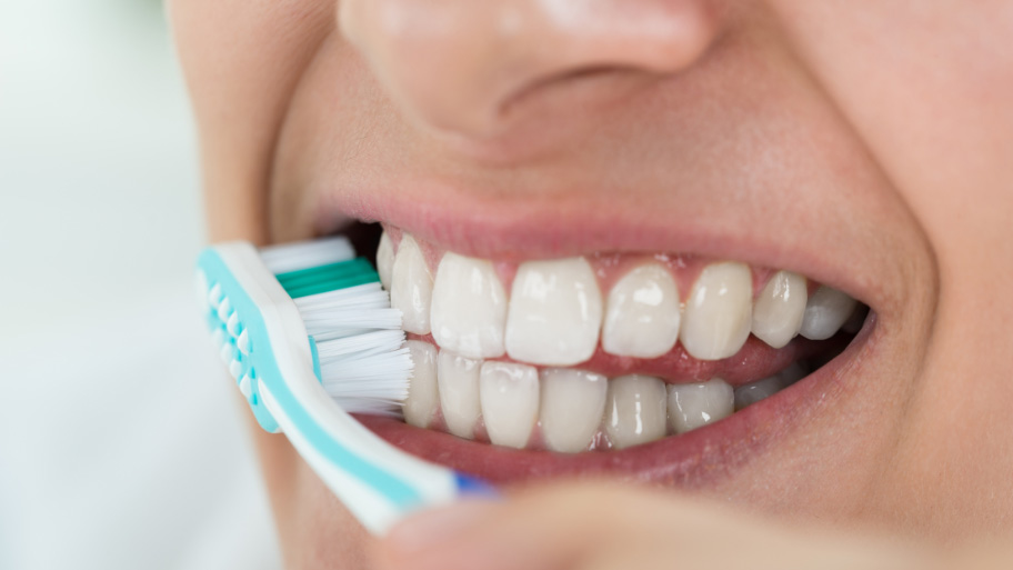 Woman Brushing her teeth gently